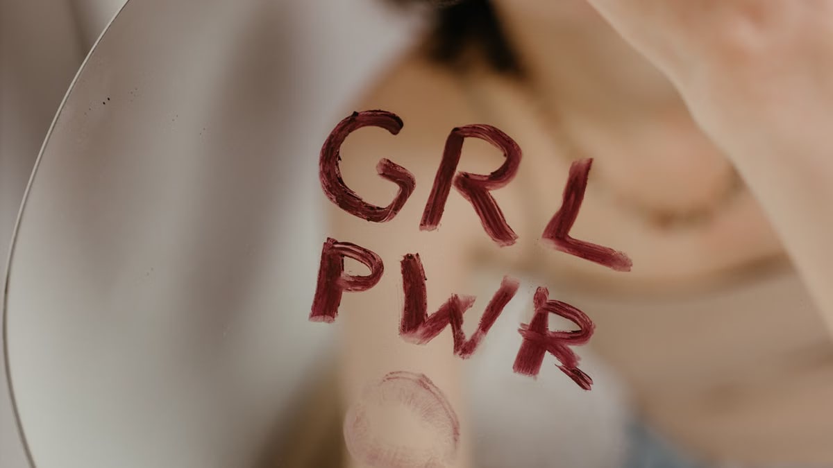 Close-up of empowering 'GRL PWR' message written on a mirror with lipstick.